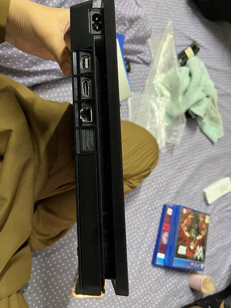 Playstation 4 slim with controllers and disks 11