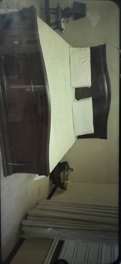 Wooden bed in dark brown colour