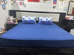 Black wooden bed with two side tables and dresser