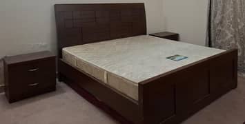 King sized wooden bed with foam and sitetables