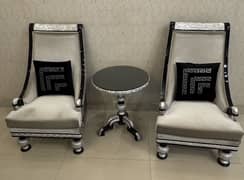 2 sofa chairs with glass top center table