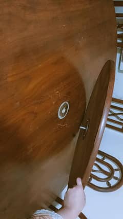 A  wooden dining table with revolving center and 5 chairs is for sale