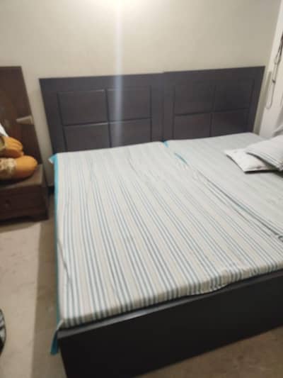 Two single wooden beds with mattress