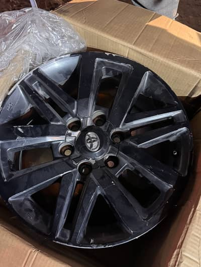 Toyota ke OEM (original) alloy rims hain (black finish)