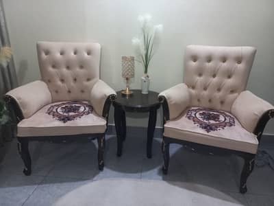 2 wooden chairs with wooden centre table