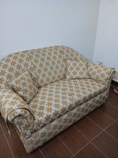 GOLDEN AND MUSTARD COLOURED 2 SEATER SOFA WITH ARM COVERS.