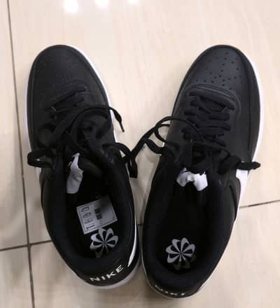 Nike Court Vision Low Next Nature shoe in black and white.