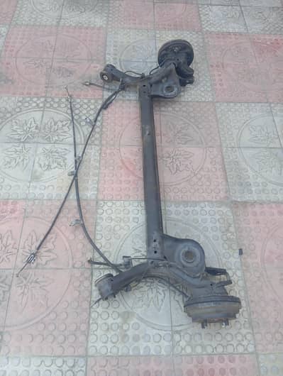 The assembly includes drum brakes and associated cables.