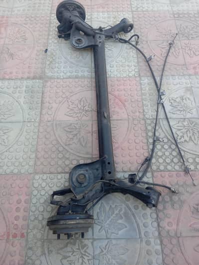 The assembly includes drum brakes and associated cables.