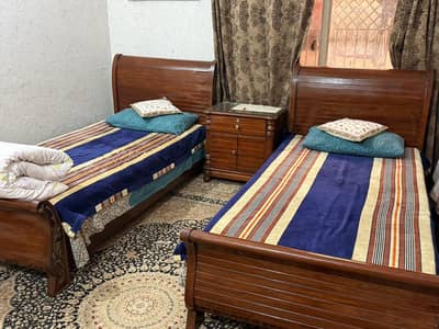 two single beds with mattress and one sidetable