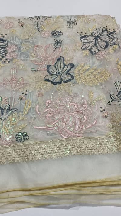 “This exquisite net shawl features delicate floral embroidery on a so