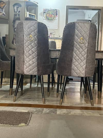 A Marble stone top dining table with 6 luxury chairs for a family dine