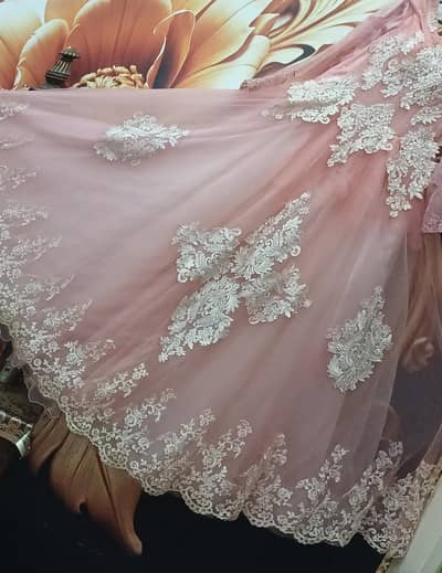 This is a pink formal gown or wedding dress with white lace appliques.