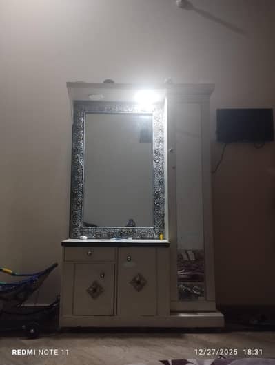 Dressing table with makeup shelves behind glass