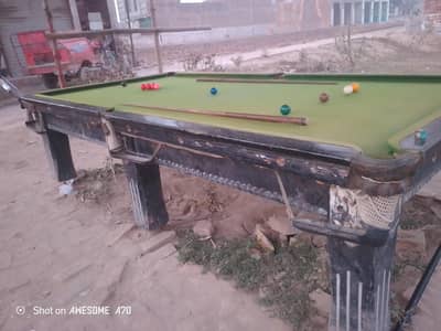 A snooker table with new balls and two sticks are for sale