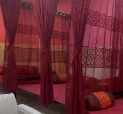 3 Charpai with Jhoola-style curtains with pillows and carpet on it