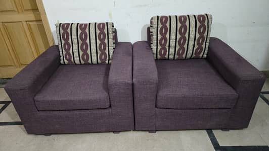 7-seater fabric sofa with a purple base and patterned back cushion.