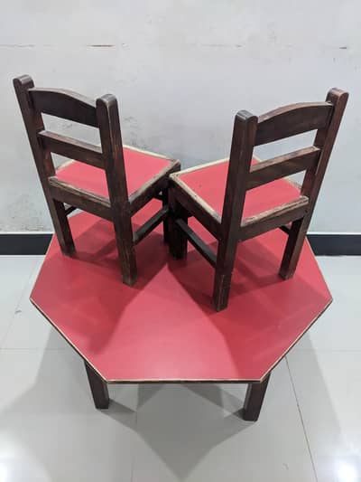 kids table and 2 chairs and wooden shelf