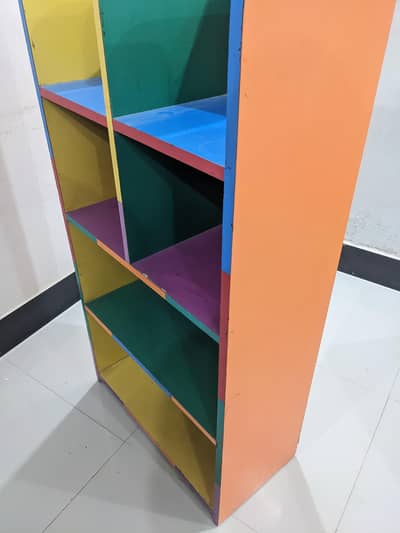 kids table and 2 chairs and wooden shelf