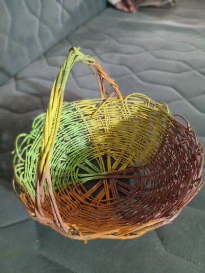 Handmade multicolor wicker basket with handle.