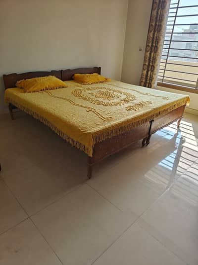 Antique wooden bed with mattress