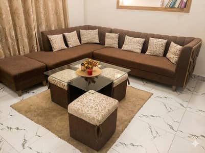 L shaped large sofa with table and stools
