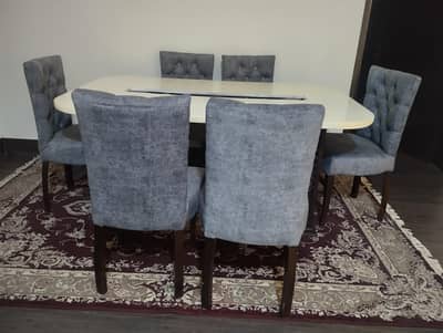 modern style dinning table with white top and neat and clean chairs