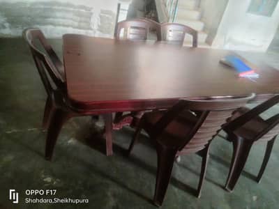 A wooden Dinning table with 6 plastic chairs same color