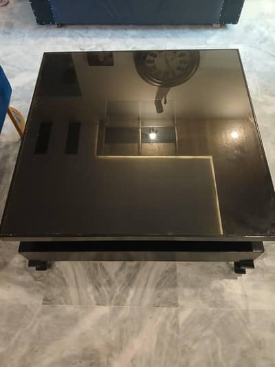 Wooden center table with glass top