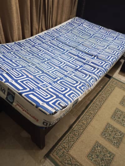 Two single beds with side table and mattress