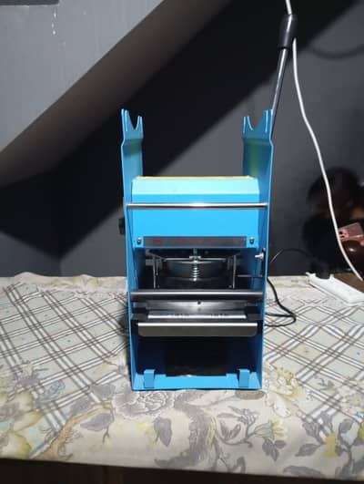 Cup sealing machine.