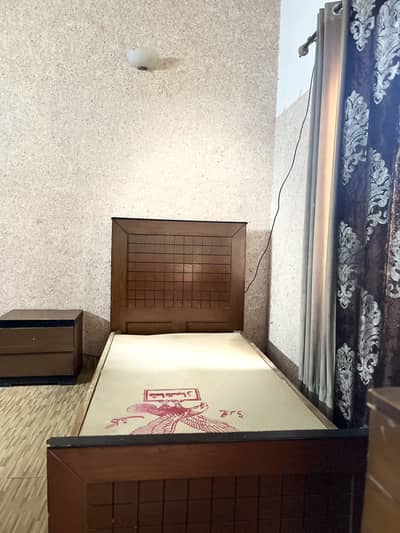 Single bed along with a side table and a dressing table