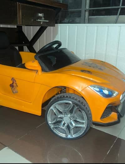 kid's car for sale. orange color. neat condition