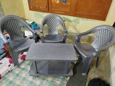 3 plastic chairs, table with double sided surface