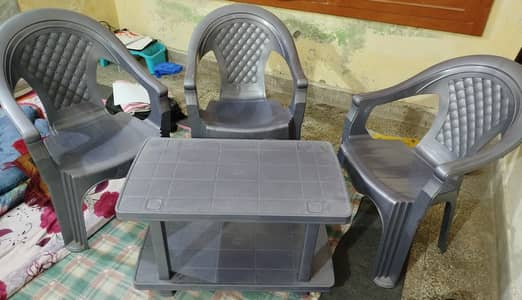 3 plastic chairs, table with double sided surface