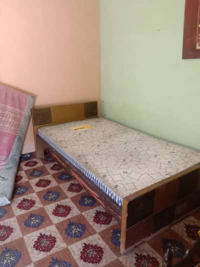 single wooden bed with metress