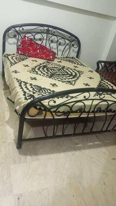 black iron Queen size bed along with dressing table.
