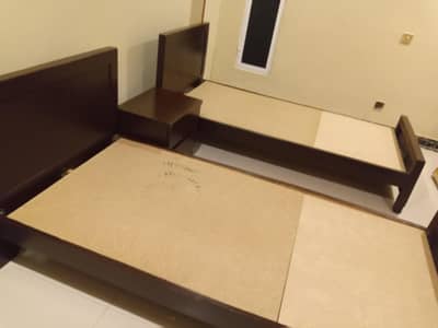 Solid two single beds with one table with mattresses