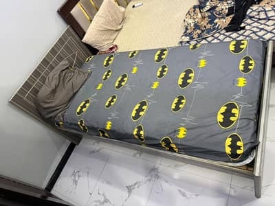 single bad with spring mattress and side table