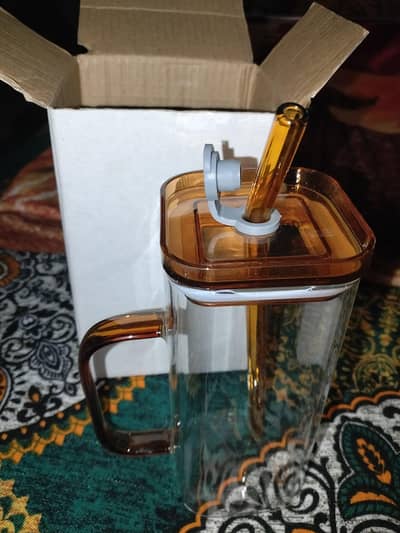 Beautiful glass mug with glass straw