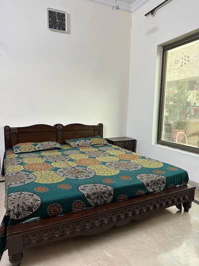 wooden bed with side tables and matress