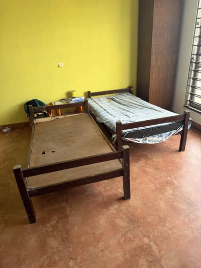 Two beds, one with mattress,