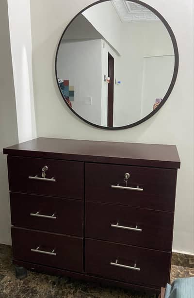 dresser with a round mirror