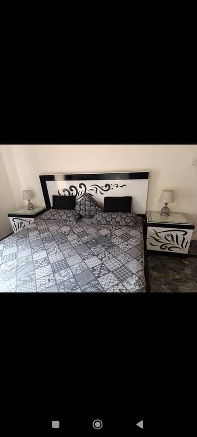 white and black king size bed set with sidetables and dressing. . .