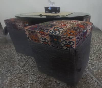 glass top coffee table with wooden base with 4 sitting chairs