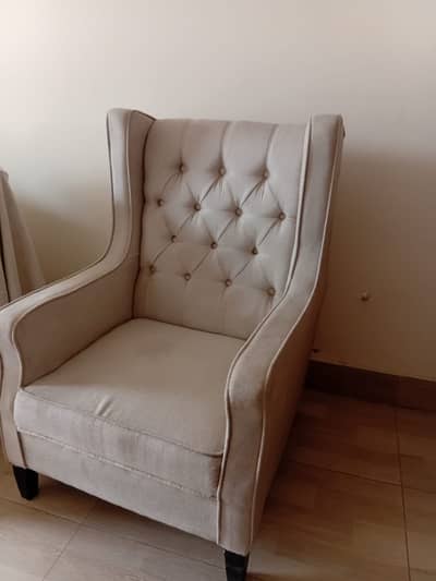 Two single seater cream colour sofa and wooden table