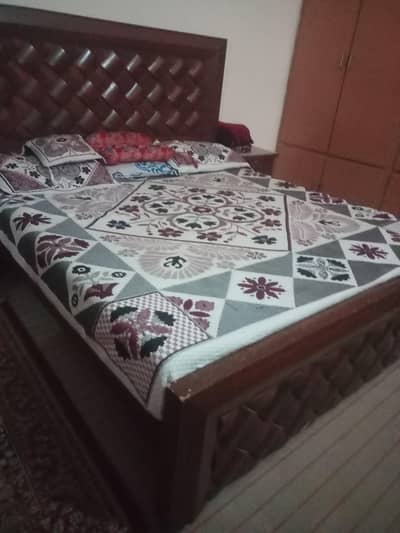 wooden bed with side tables and mattress
