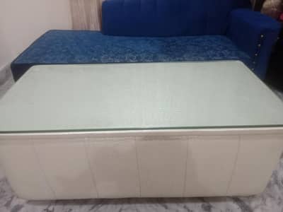 modern white leather storage ottoman center table with a glass top.