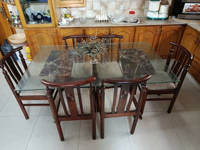 Dinning table . It's a glass table with six wooden chairs