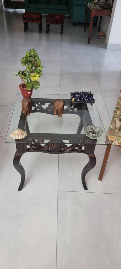 Beautiful carved wooden tables with glass top.